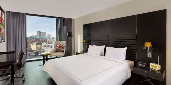 Image of a modern hotel bedroom with stunning view of London - inside a bedroom of art’otel London Hoxton