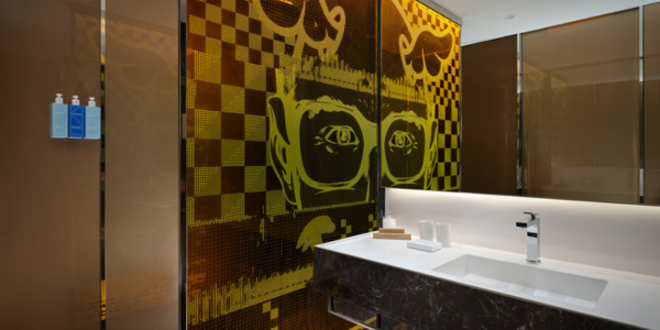 Image of a modern hotel bathroom sink area with art on the wall - inside a bedroom on suite bathroom of art’otel London Hoxton