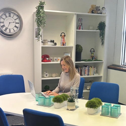 Bien Venue's Managing Director, Kerry Evans, sat at a meeting table looking at her laptop screen