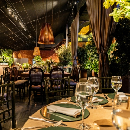an indoor dining room with lots of greenery, to represent a venue review blog